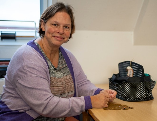 Bruger af Rehabilitering og Udviklingscenter, Filadelfia, sidder med sytøj