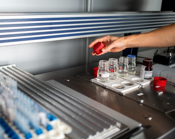Foto af små flasker med skruelåg på Filadelfias Laboratorie i Dianalund