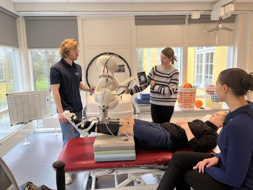 Patient med hjerneskade på Center for Neurorehabilitering træner med robotteknologi med integreret Sensing and Stimulation modul,