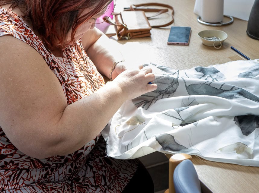 Bruger på Rehabilitering og Udviklingscenter, Filadelfia i Dianalund syer. Produkterne sælges i værkstedsbutikken.