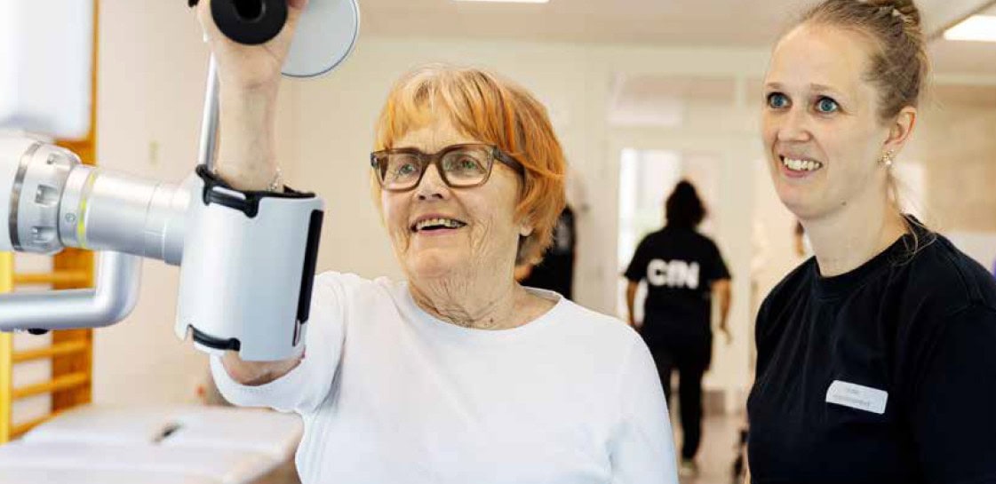 Patient på Center for Neurorehabilitering træner arm med medarbejder